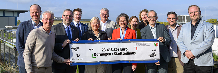 Das Foto zeigt eine große Versammlung der Stadtvewaltung und Ministerin Scharrenbach, die den Förderbescheid für das Stadtteilhaus begrüßen
