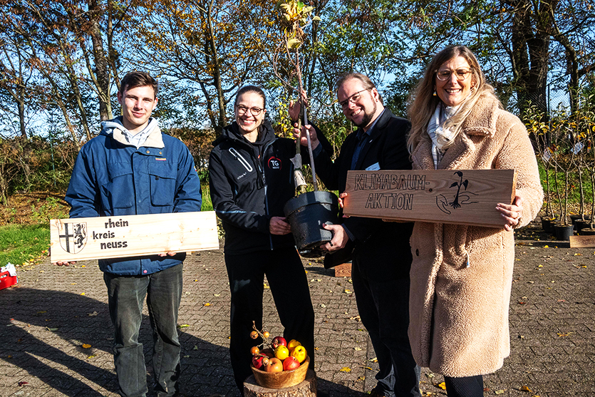 Das Foto zeigt: Jakob Faßbender, Katharina Jager, Kreisdezernent Gregor Küpper und Verena Krause und einen Baum